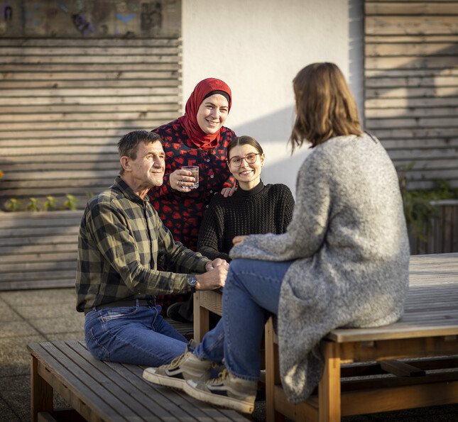 Vier Klient*innen der Caritas Steiermark unterhalten sich